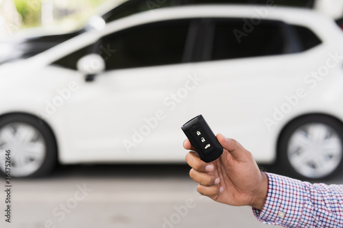 Close up car keys and remote control car alarm systems hold in hand. Young man buy the new car.