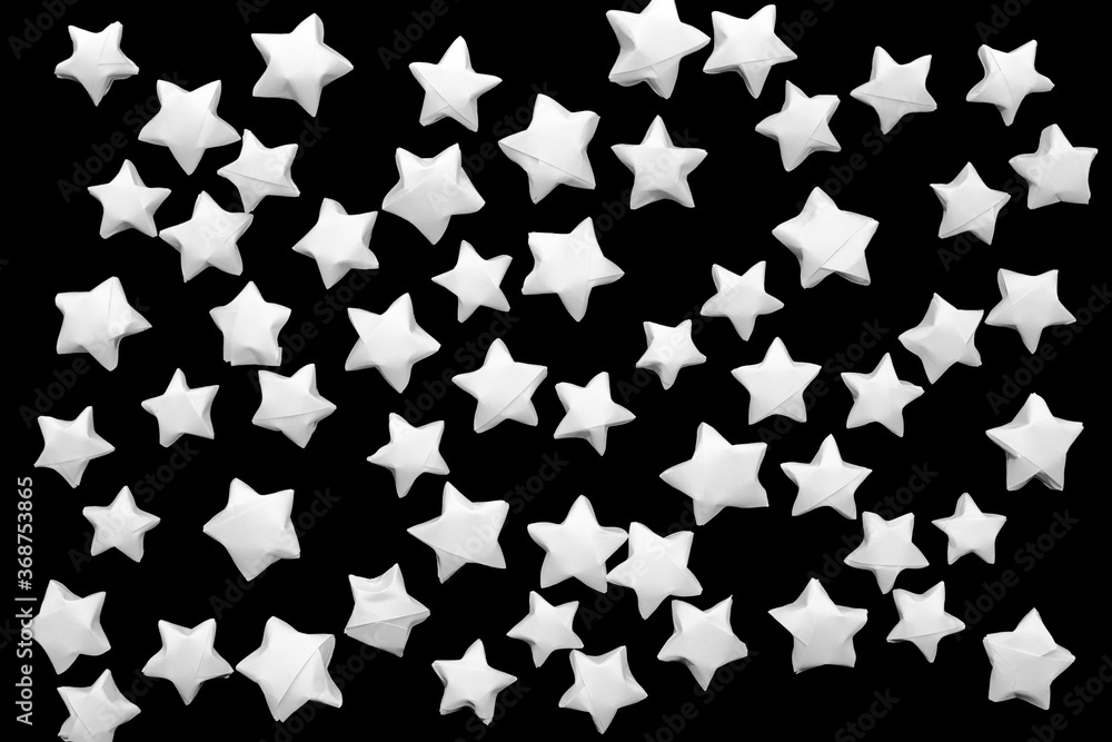 Dark background of white paper stars on a black background Dark background of white paper stars on a black background
