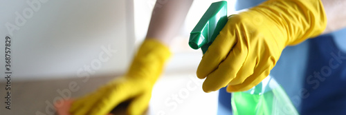 Φωτογραφία Hands in yellow gloves disinfect with wooden table