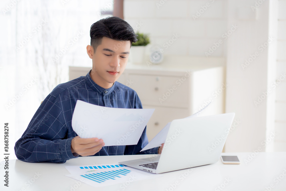 Young asian business man looking document data graph and chart paper, marketing and investment, report of statistics profit for financial, economic and growth of finance, management and planning. Young asian business man looking document data graph and chart paper, marketing and investment, report of statistics profit for financial, economic and growth of finance, management and planning.