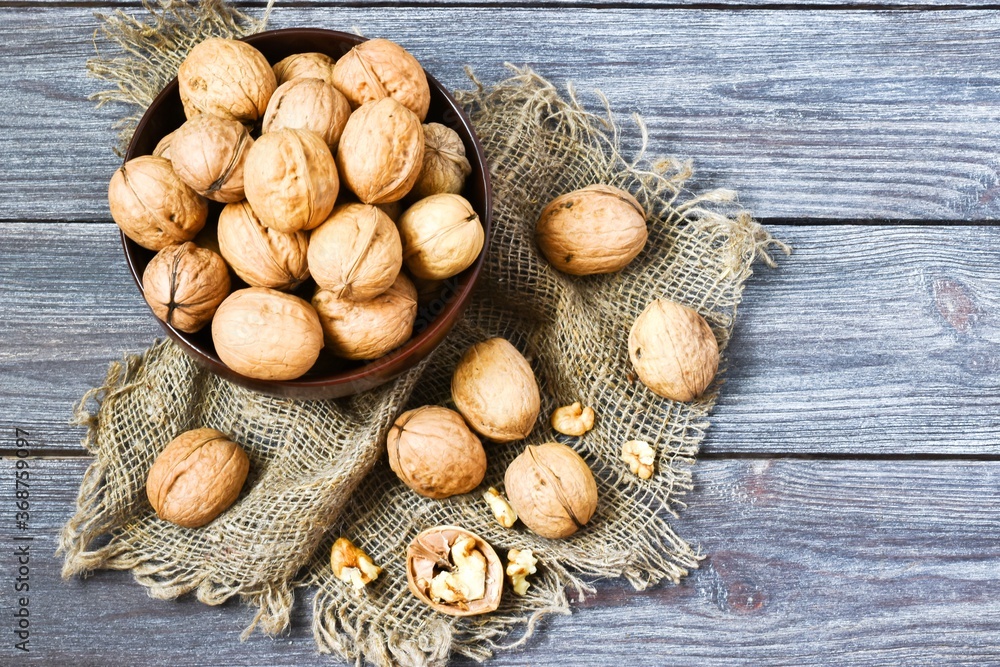 Walnuts in bowl on wooden background.Healthy food concept. With copy space, top view, flat lay. Walnuts in bowl on wooden background.Healthy food concept. With copy space, top view, flat lay.