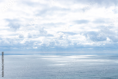 calm blue sea and sun rays penetrating through the clouds in the sky. marine landscape