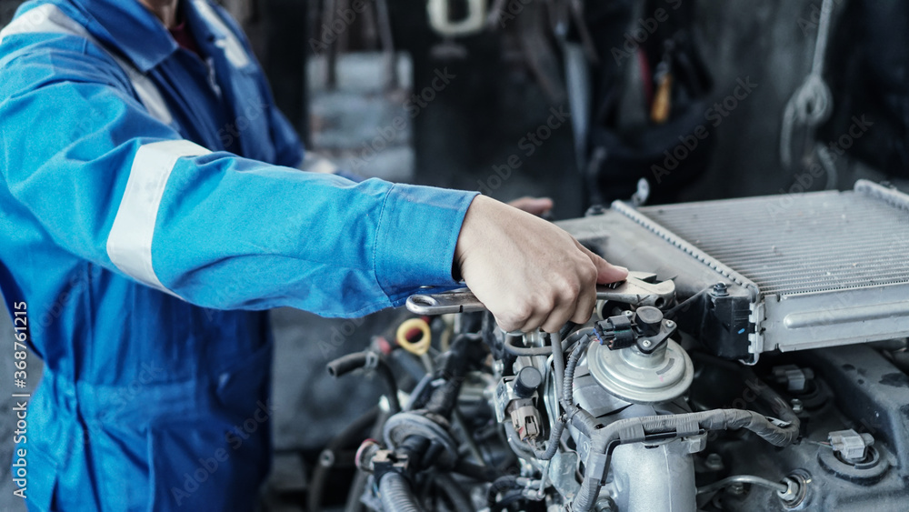 Mechanic auto mechanic in uniform repairing.car in auto machine tools ready to be used with car service.selective focus. Mechanic auto mechanic in uniform repairing.car in auto machine tools ready to be used with car service.selective focus.