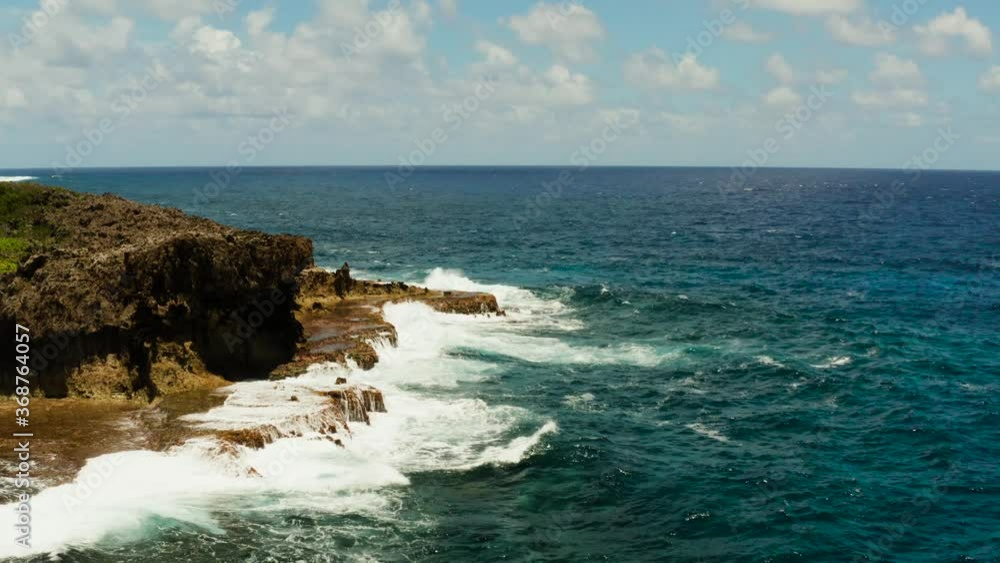 Coastline of the island and the surf with waves crashing against a rocky coast, aerial view. Siargao,Philippines. Summer and travel vacation concept Coastline of the island and the surf with waves crashing against a rocky coast, aerial view. Siargao,Philippines. Summer and travel vacation concept