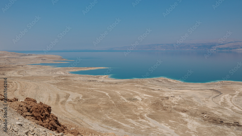 Dead sea landscape wide angle shot. Dessert terrain with sinkholes in the foreground and mountains of Jordan in far background. Dead sea landscape wide angle shot. Dessert terrain with sinkholes in the foreground and mountains of Jordan in far background.