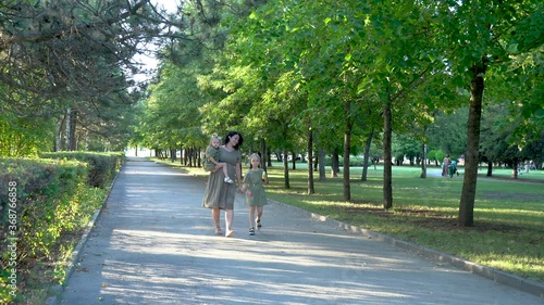 Wallpaper Mural a pregnant mother with two daughters walks in a green Park. Torontodigital.ca