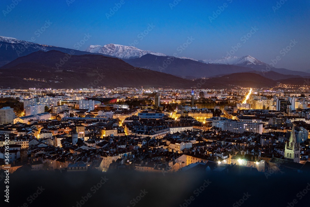 Grenoble vue de haut la nuit en panorama, montagne en fond