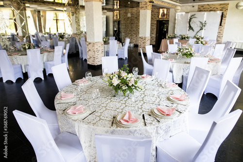 Festive table setting with wine glasses, and fresh flowers photo