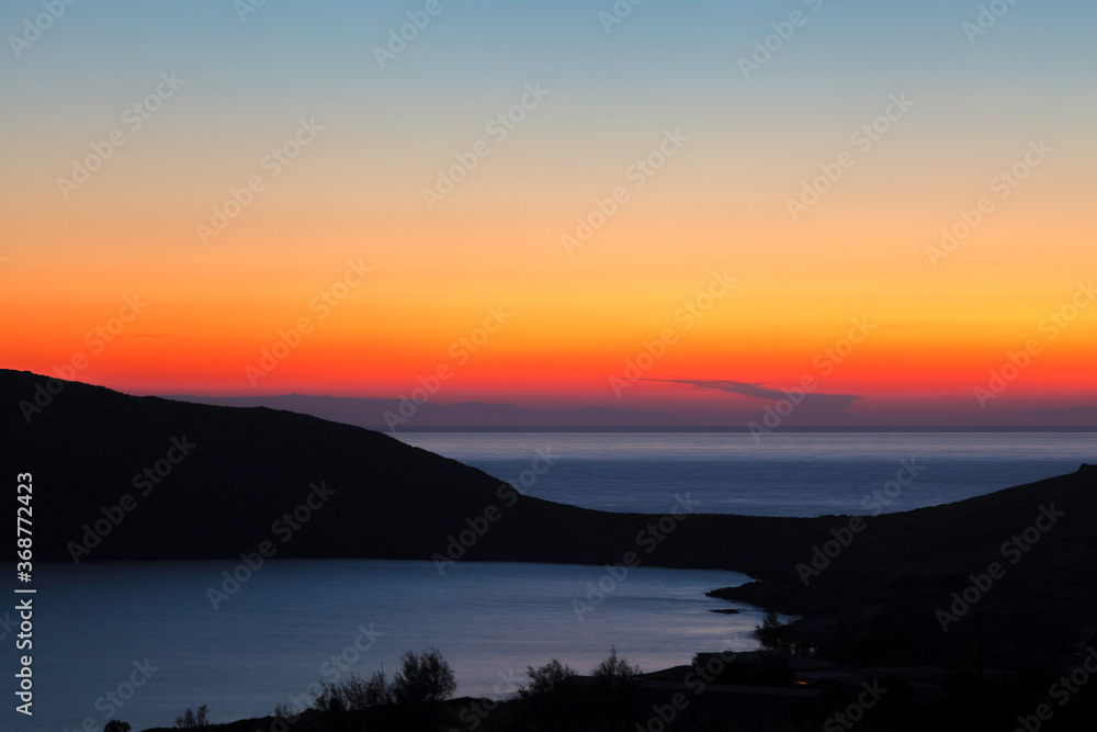 Sunset at Delfini bay, in Syros island, Cyclades, Greece, Europe.