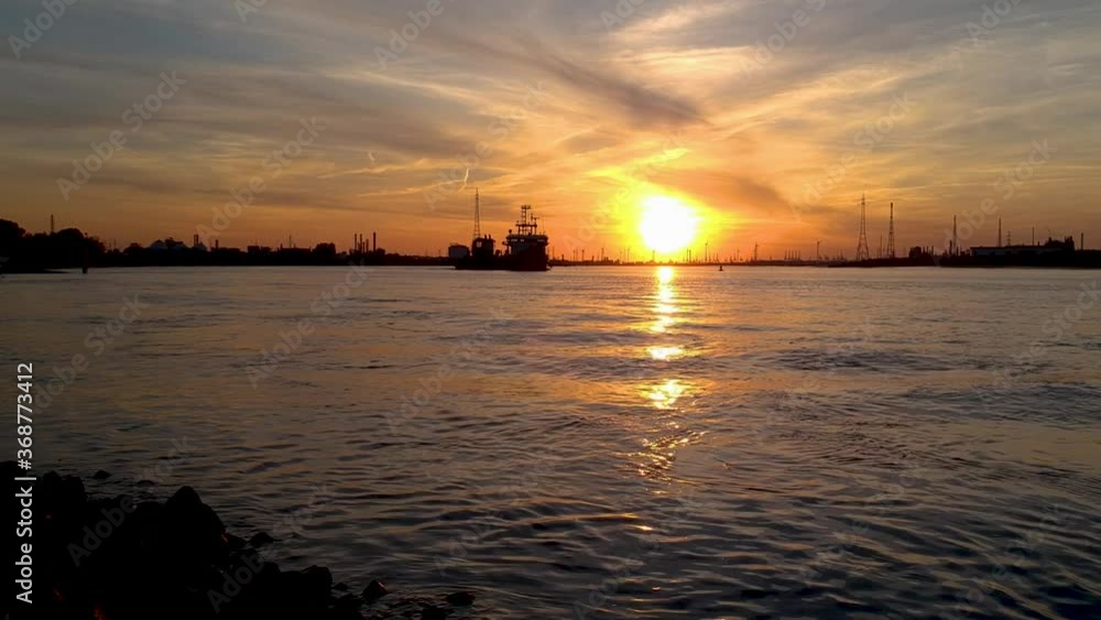 Dramatic low angle push in shot of international port antwerp at sunset. Silhouette cargo ship Dramatic low angle push in shot of international port antwerp at sunset. Silhouette cargo ship