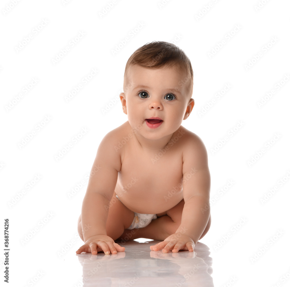 Cute little baby girl infant naked in diaper try to creep on floor smiling and looking aside isolated on white background