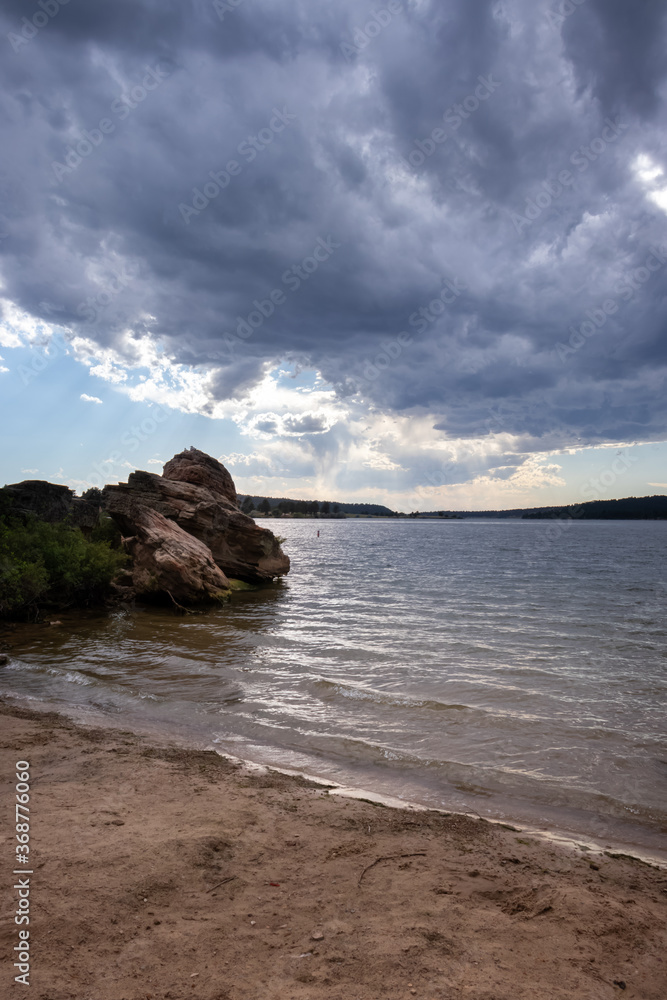 Rocks and beach at Keyhole Reservoir in Wyoming with storm clouds moving out. 