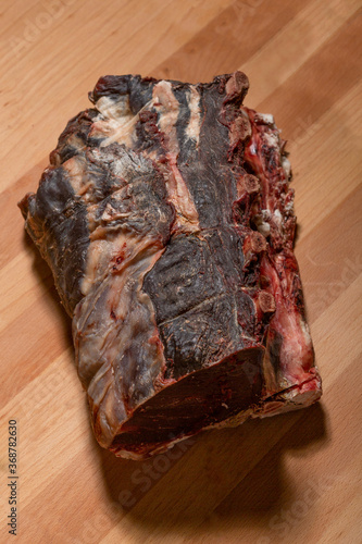 Raw dry aged ribs on wooden board