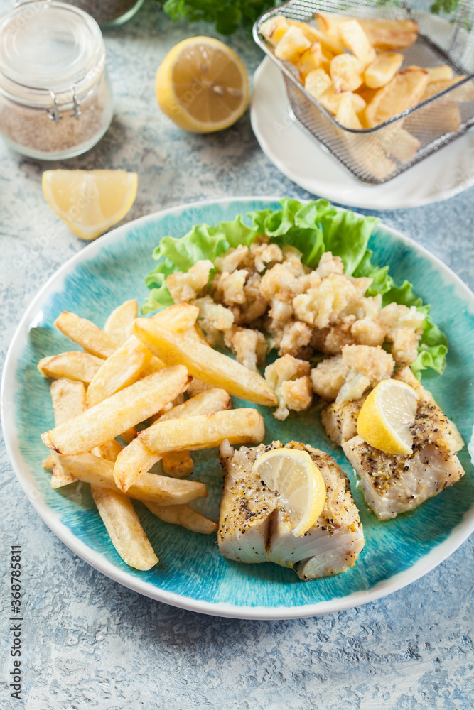 Steamed cod fish with french fries and boiled cauliflower Steamed cod fish with french fries and boiled cauliflower