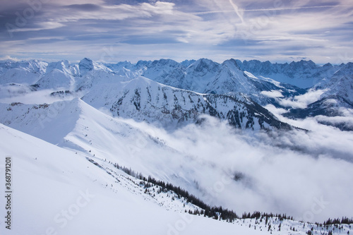 Winter panorama landscape in the Karwendel mountains at Schafreiter, with fog, snow and forest. © Bastian Linder