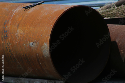 large and big iron pipe with rust outside in the sun
