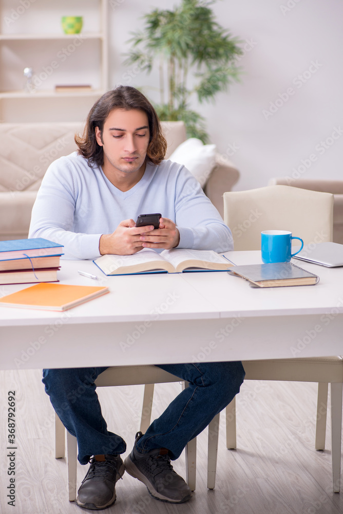 Young male student preparing for exams at home