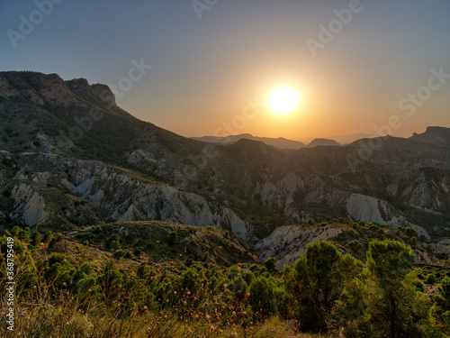 Wide view of the mountains of the Spanish region of Murcia. It is a summer evening. A romantic sunset bathes the landscape in a warm light.