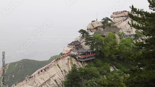 Tourists climbing magnificent Mount Hua or Huashan, a mountain near city of Huayin in Shaanxi, about 120 km east of Xi'an. One of 5 Great Mountains of China with long history of religious significance photo