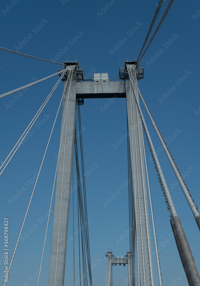 Supports of a suspension bridge with cables against the blue sky. Supports of a suspension bridge with cables against the blue sky.