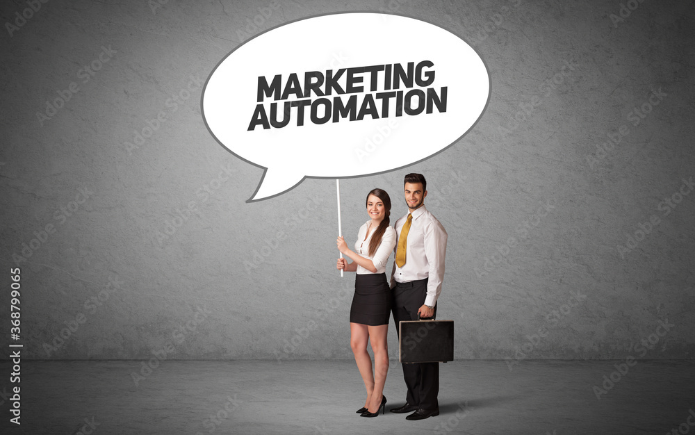 Young business person in casual holding road sign with MARKETING AUTOMATION inscription, new business idea concept Young business person in casual holding road sign with MARKETING AUTOMATION inscription, new business idea concept