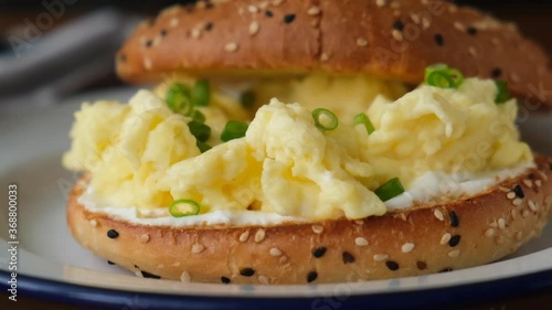 Bagel toast with scrambled egg and scallions. Closeup view breakfast sandwich with egg