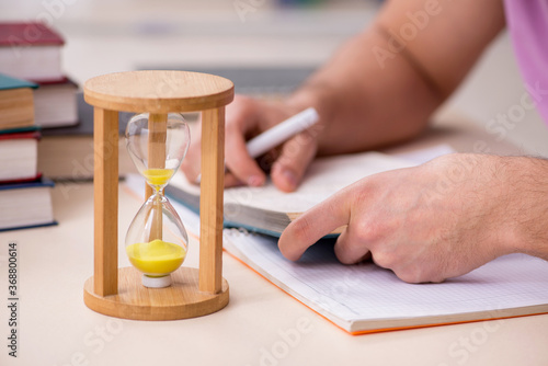 Young male student in the classroom at time management concept