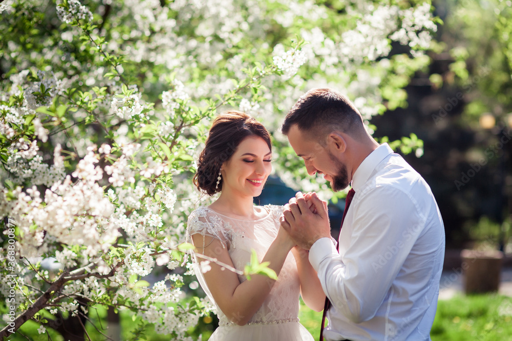 bride and groom in a blooming spring garden bride and groom in a blooming spring garden