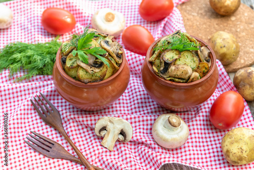 Baked potatoes with chicken and mushrooms in a clay pot at home.
