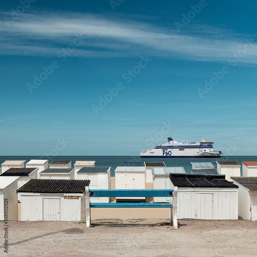 Massive ferry sailing in front of the beach of Calais.