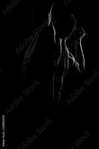 Silhouette of young athlete bodybuilder man on black © sameer