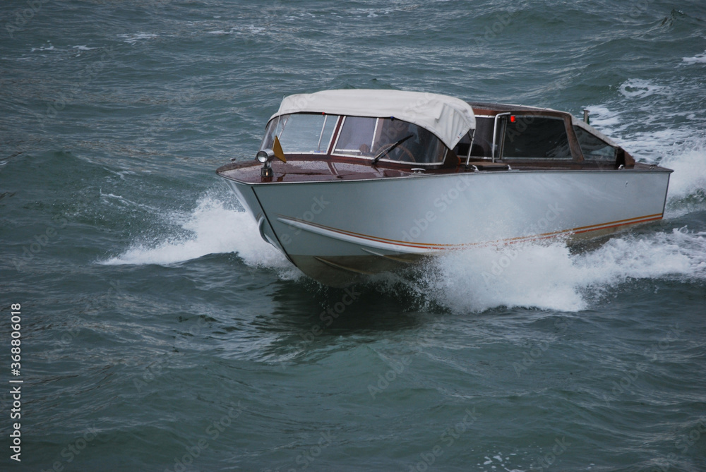 Fototapeta premiumwhite motorboat in the waves on a rainy day