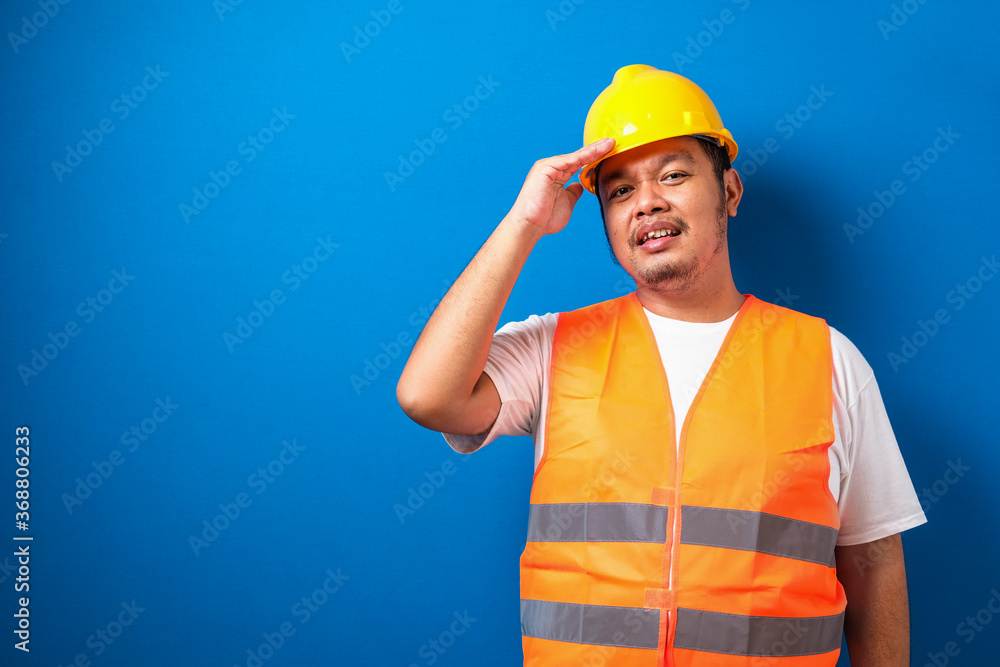 Fat asian constructuion worker man wearing safety helmet stressed with hand on head