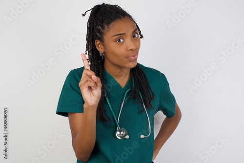 Woman gesturing a no sign. Closeup portrait unhappy, serious girl raising finger up saying: oh no you did not do that. Standing over yellow background. Negative emotions facial expressions, feelings. photo