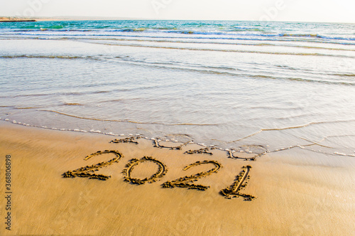 Happy New Year 2021 text on the sea beach. Abstract background photo of coming New Year 2021 and leaving year of 2020