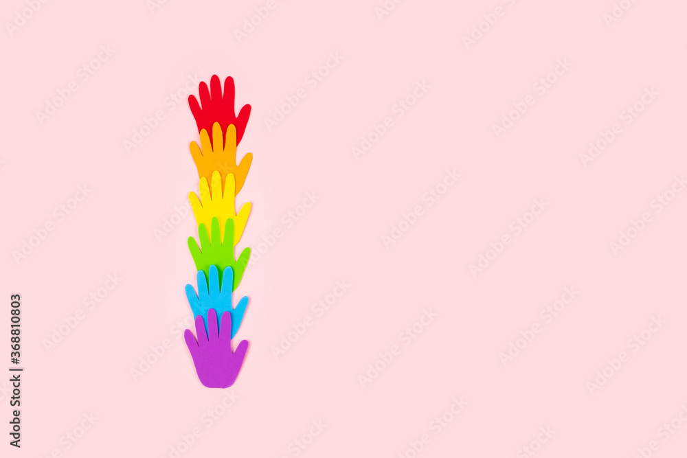Pride, LGBT flag symbol concept with rainbow color palm hands heart butterfly shape on pink background with copy space