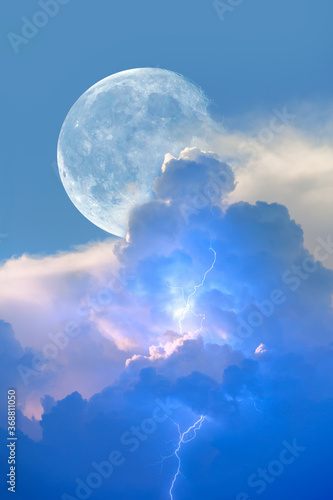 Lightning strikes between blue stormy clouds with full moon "Elements of this image furnished by NASA" 