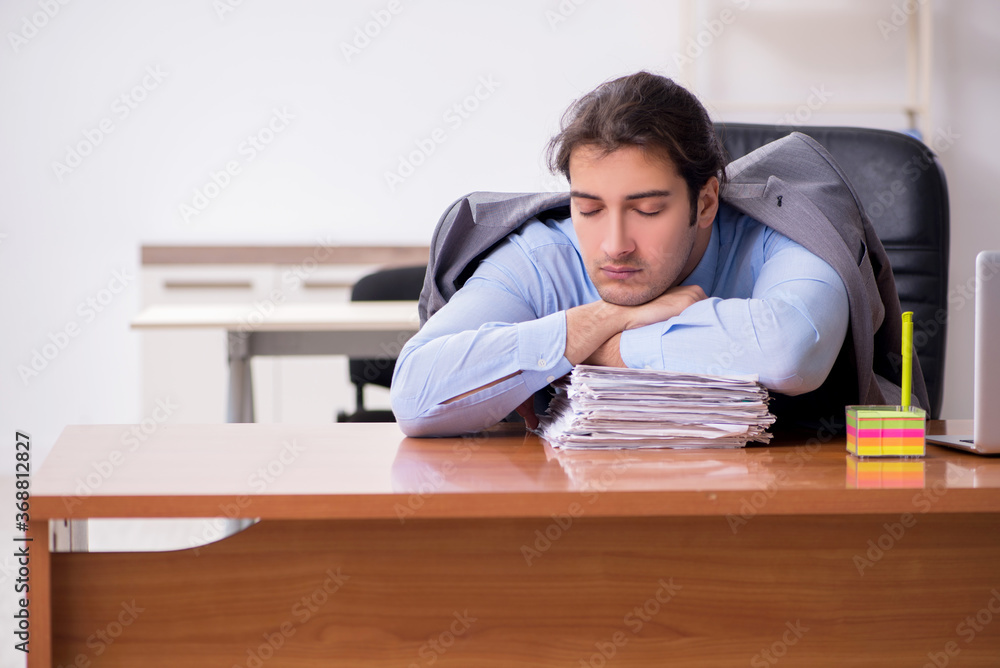 Young male employee sleeping in the office Young male employee sleeping in the office