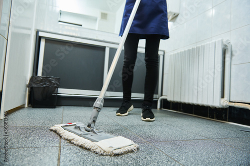 cleaning service. wiping toilet floor with mop