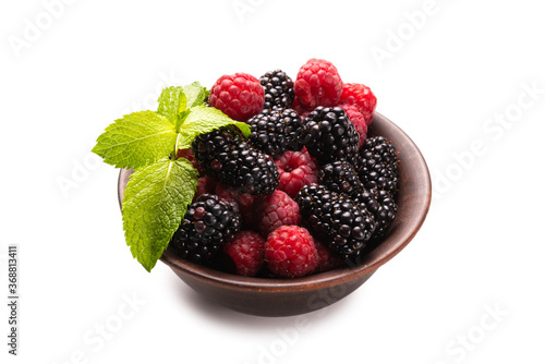 Raspberry  blackberry and mint leaf in ceramic brown bowl isolated on white