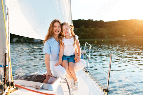 Mother And Daughter Sitting On Yacht Smiling To Camera Outside