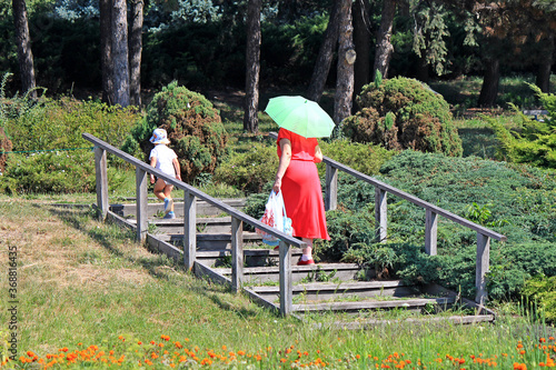 Fototapeta Naklejka Na Ścianę i Meble -  grandmother with her grandson on a walk in the botanical garden