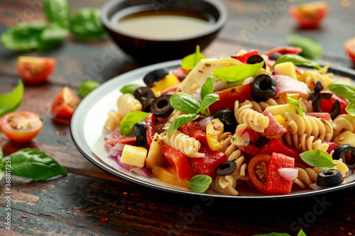 Photography Antipasto salad with pasta, tomato, olives, red onion, bell pepper, salami, cheese, artichoke and basil