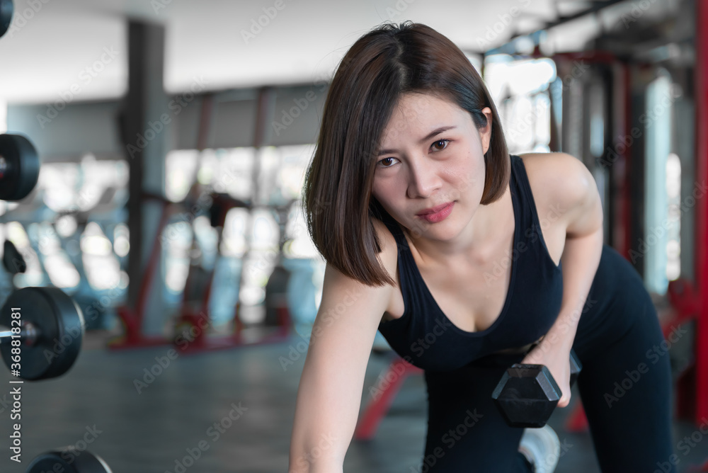 Fototapeta premium Beautiful asian woman play fitness in the gym,Thailand girl has a slim body,Time for exercise,People love heath,Stretching body before workout,Sport woman warm up body,push up with dumbell