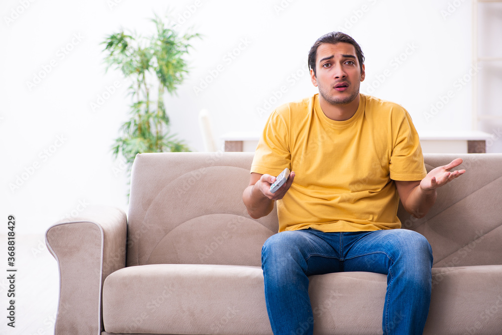 Fototapeta premium Young man watching tv at home