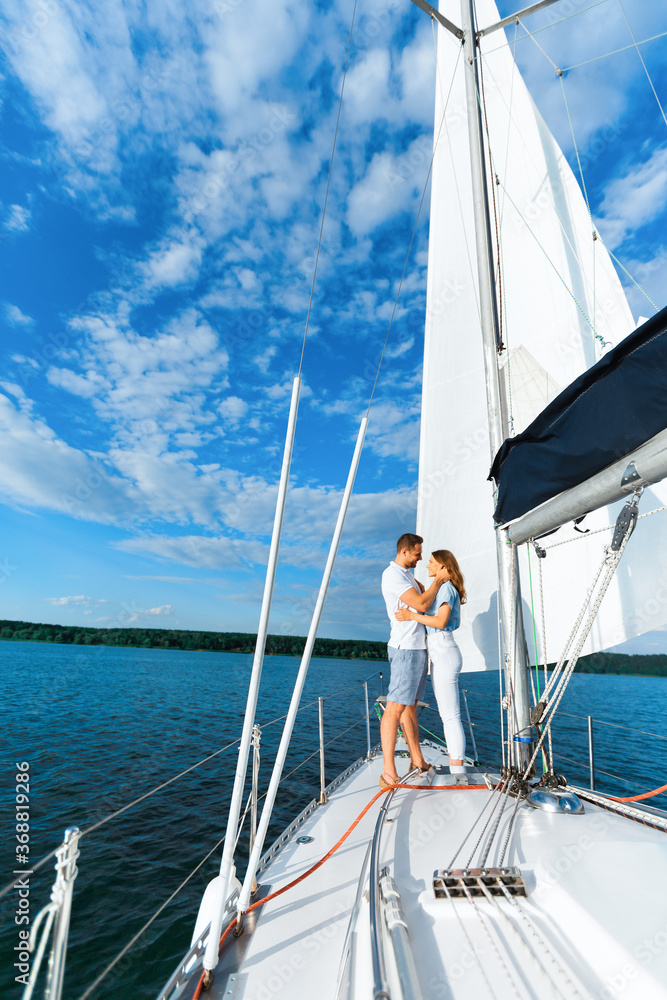 Couple On Yacht Hugging Sailing At Seaside, Enjoying Vacation, Vertical Couple On Yacht Hugging Sailing At Seaside, Enjoying Vacation, Vertical