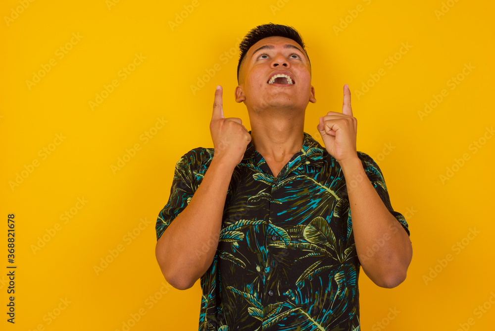 Charming carefree man with positive expression, points up with both index fingers, dressed in casual clothing, has broad intrested smile, isolated over pink background. Look there, please†Charming carefree man with positive expression, points up with both index fingers, dressed in casual clothing, has broad intrested smile, isolated over pink background. Look there, pleaseâ€