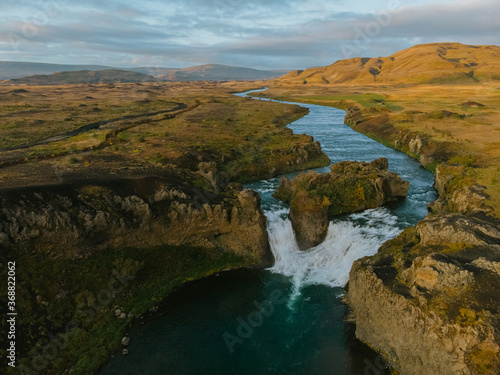 Hjalparfoss waterfall in South Iceland at sunset, aerial top view from drone. Beautiful nature landscape