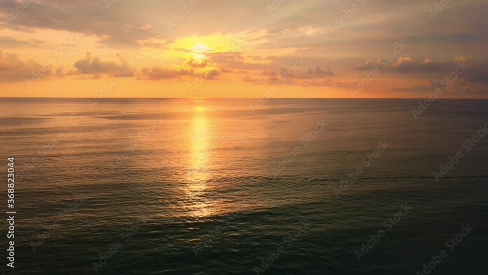 4K Aerial view Drone view moving forward over the sea to sunset with clouds and sunlight reflect from sea. Beautiful Phuket beach is famous tourist destination at Andaman sea. 4K Aerial view Drone view moving forward over the sea to sunset with clouds and sunlight reflect from sea. Beautiful Phuket beach is famous tourist destination at Andaman sea.