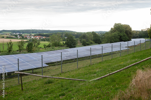 Beautiful sceenery of a little solar park in Bavaria, sourrounded by beautiful landscape in a little valley. Photograph was taken meanwhile sunset